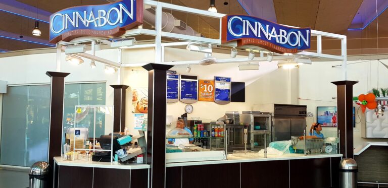 CINNABON kiosk at Queen Beatrix Airport Aruba on arrival waiting area scaled 1 768x373